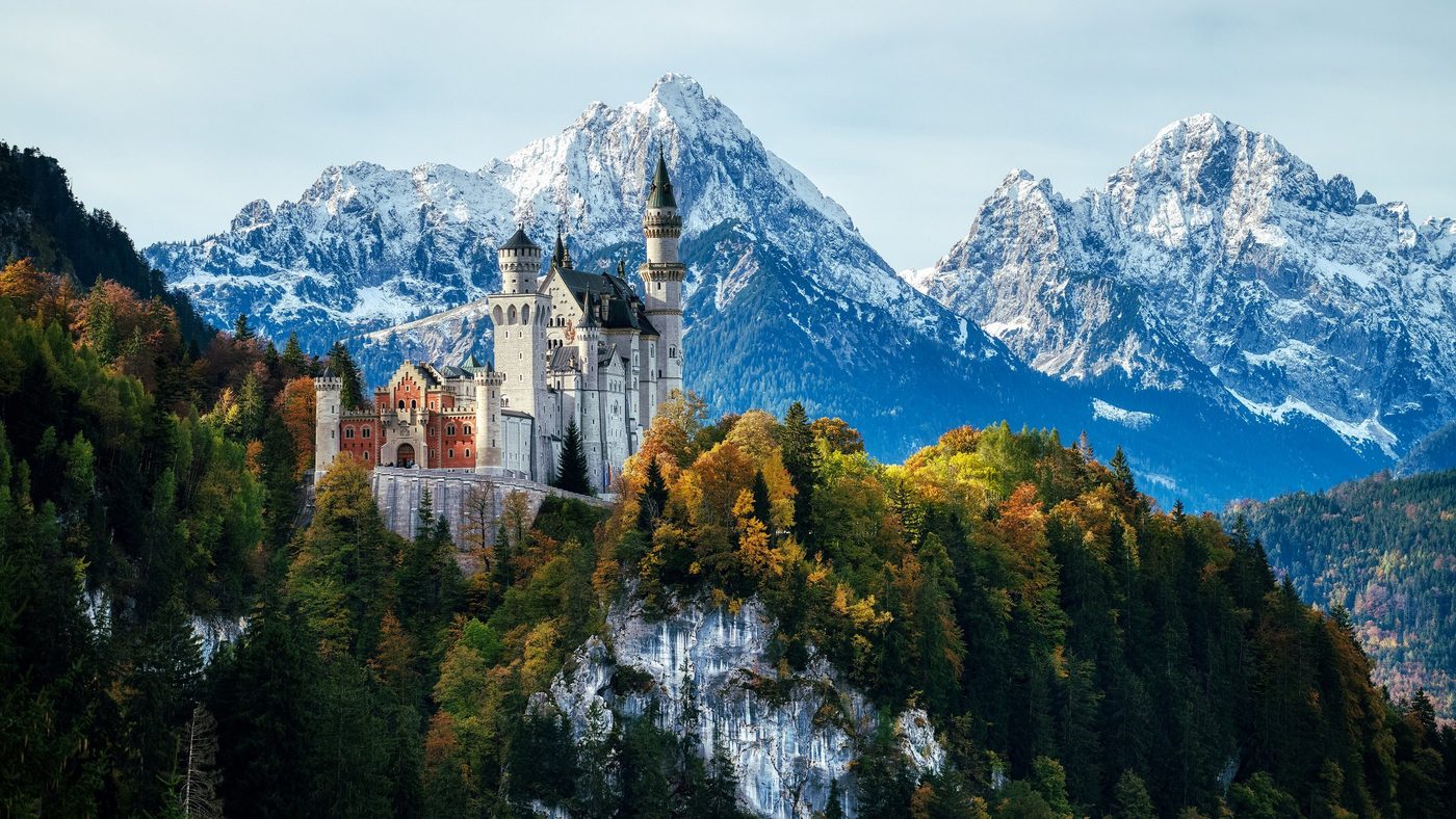 Neuschwanstein Castle in autumn beneath the snowy Alps
